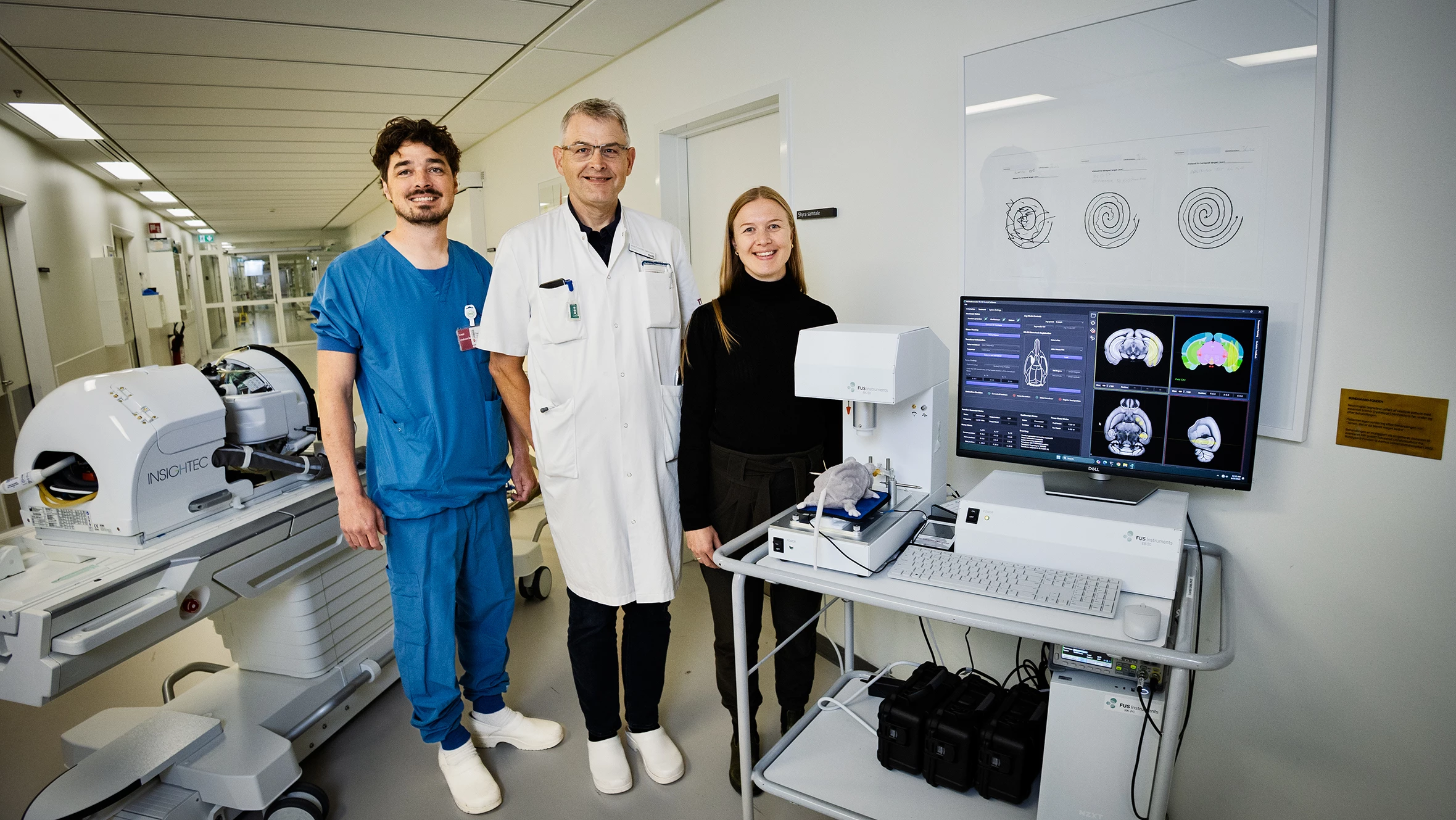 Tre forskere står ved udstyr til fokuseret ultralyd