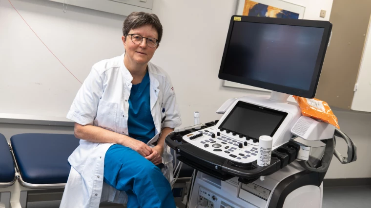 Kvinde i kittel ved måleapparat